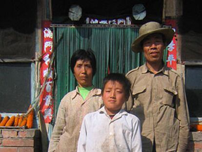 El matrimonio Wang, con un sobrino, delante de su casa en Nongzhong.