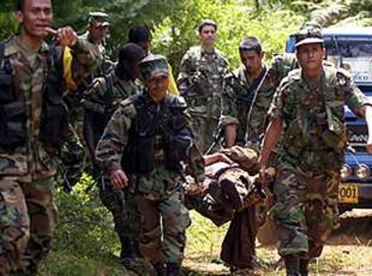 Varios soldados portan el cuerpo de un compañero herido en una emboscada de la guerrilla cerca de la ciudad de Cali.