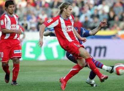 Forlán, ante Agüero, en la acción del gol del Atlético.