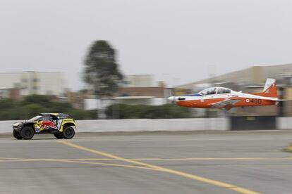 Los pilotos Sebastien Loeb (Francia) y Daniel Elena (Mónaco) compiten contra un avión en una carrera de exhibición, en la inauguración del Dakar 2019, en Lima (Perú), el 6 de enero de 2019.