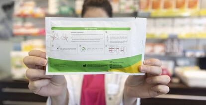 Una farmacéutica muestra un test de antígenos en una farmacia, en Madrid.