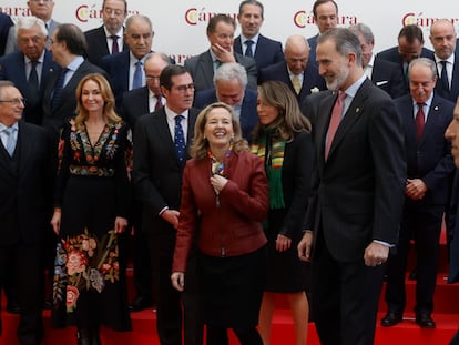 El rey Felipe VI sonríe en presencia de la ministra de Economía, Nadia Calviño y del presidente de la CEOE, Antonio Garamendi, en la Cámara de Comercio este miércoles en Madrid.
