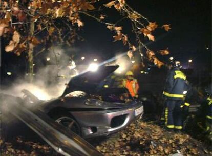 Un bombero, junto al Ferrari accidentado.