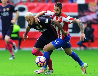 Neymar (i) del FC Barcelona y Santos Junior del Sporting intentan hacerse con el balón.