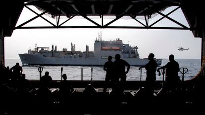 Los marineros del barco de asalto anfibio USS Boxer esperan suministros en el hangar durante una reposición vertical en el mar, en el Golfo de Adén, Mar Arábigo. 