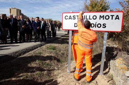 Workers change the village sign.