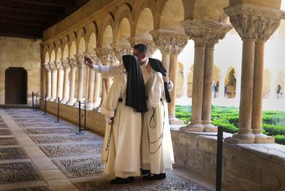 Tres religiosos se hacen una foto en el claustro del monasterio.  