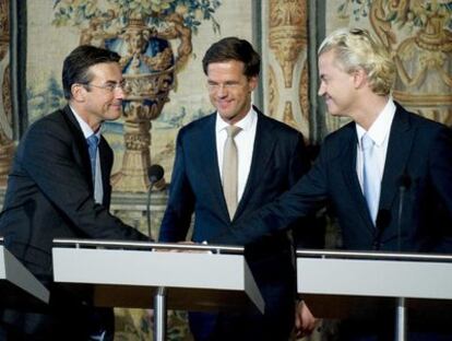 El próximo primer ministro de Holanda, el liberal Mark Rutte; rodeado por el democristiano Maxime Vergahen (izquierda), que será viceprimer ministro del Gobierno de coalición entre liberales y democristianos; y el ultraderechista Geert Wilders (derecha), cuyo Partido de la Libertad prestará apoyo parlamentario al futuro Ejecutivo. En la presentación, hoy en La Haya, del pacto de gobierno se ha informado de que uno de los objetivos es la prohibición total del <i>burka</i>.