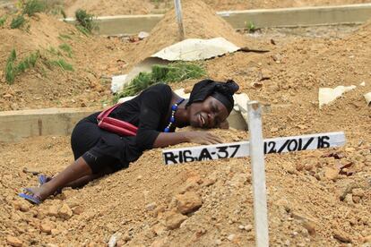 Una mujer visita la tumba de su padre del día de difuntos en el cementerio de Margibi, Liberia.