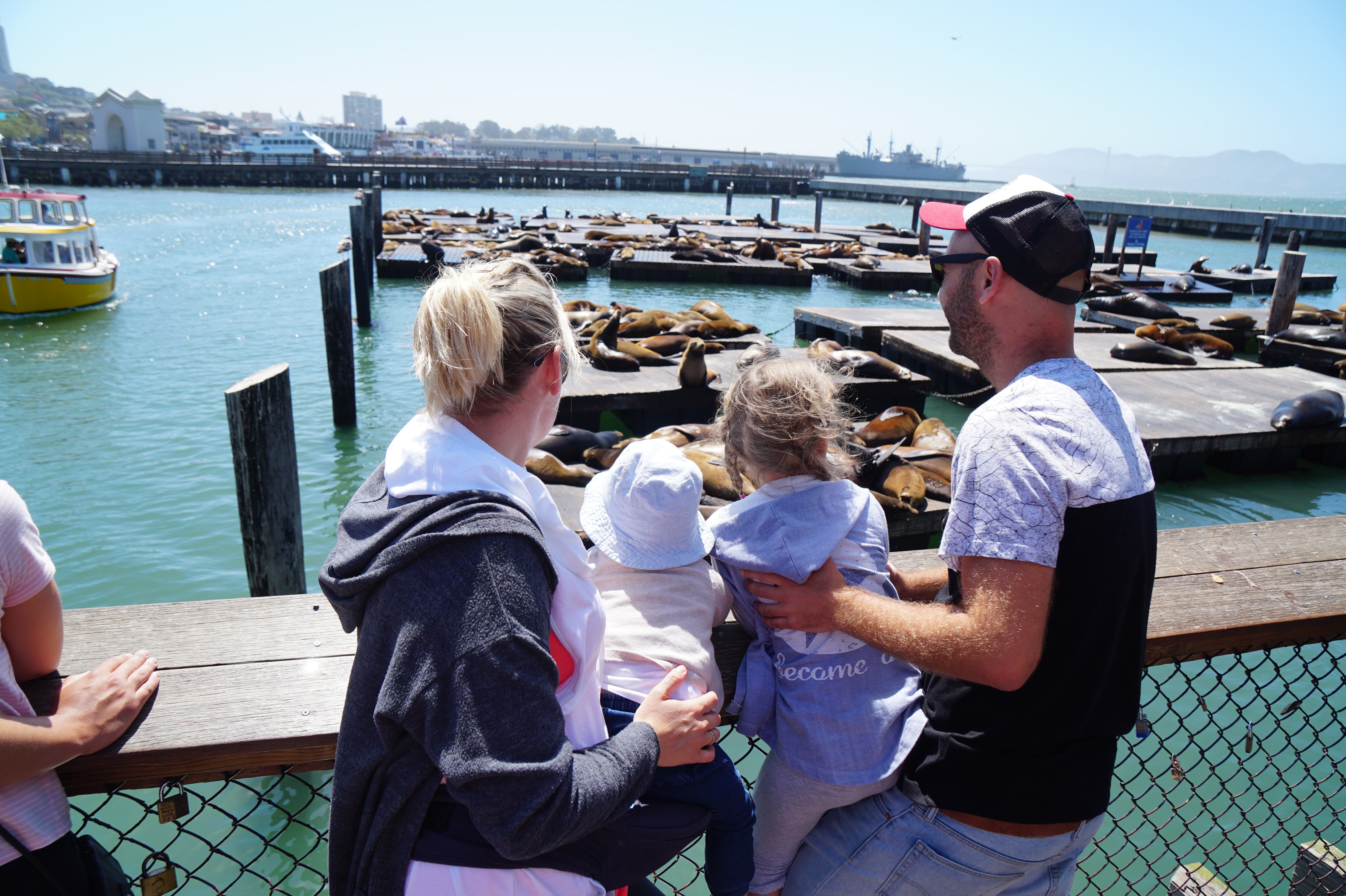 Adrián Rodríguez y Gosi Bendrat, con sus dos hijos, viendo leones marinos en el Pier 39 de San Francisco (California).