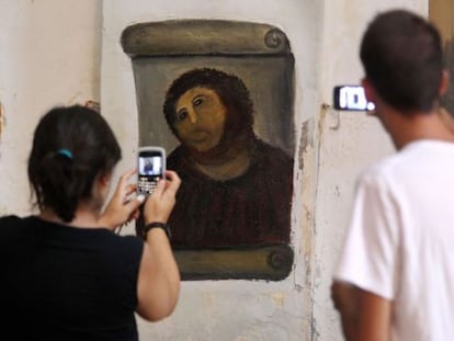 Dos curiosos miran la imagen del 'Ecce Homo'