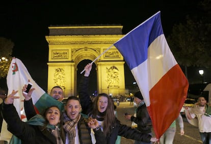 Un grupo de aficionados franceses se une a otro de argelinos para celebrar junto al Arco del Triunfo de París la clasificación de ambas selecciones.