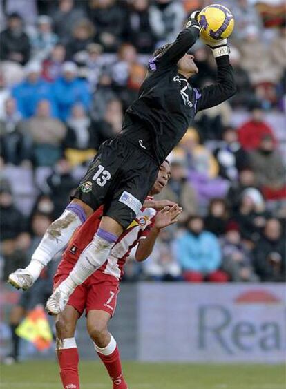 El guardameta del Valladolid, Justo Villar, detiene un balón ante la presencia de Valdo.