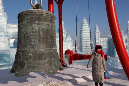 Un visitante posa para una fotografía frente a una de las instalaciones en el festival anual de hielo en Harbin.