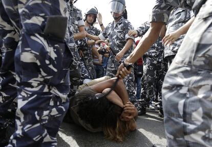 Policías antidisturbios golpean a dos manifestantes que protestaban contra el gobierno en Beirut (Líbano). Al menos diez personas resultaron heridas en choques entre agentes y manifestantes, que trataban de impedir la llegada de los líderes libaneses a la mesa del diálogo y entrar por la fuerza al Parlamento.