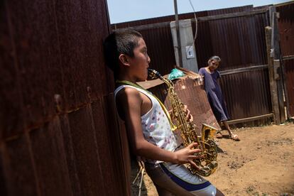 Zaachila, Oaxaca. Ángel y Juana viven en una habitación de chapa construida sobre un descampado. En su casa, Ángel toca el saxofón ante la atenta mirada de su prima. ‘Ángeles Azules’ es su canción favorita. “Cuando acabe mi tratamiento volveré a clases de saxofón”, cuenta el pequeño, que quiere ser músico cuando crezca.