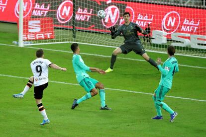 El portero del Real Madrid, el belga Thibaut Courtois, trata de parar el disparo de Kevin Gameiro, delantero francés del Valencia, durante el partido entre ambos equipos correspondiente a la primera semifinal de la Supercopa de España de fútbol