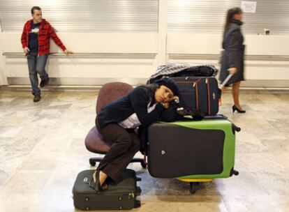 Una mujer, como otros miles de pasajeros, espera en el aeropuerto de Barajas una solución al cierre repentino de Air Comet.