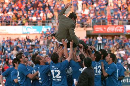 Los jugadores del Getafe mantean a su entrenador, Quique Flores, al término del encuentro.
