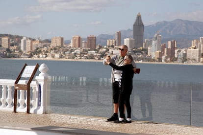 Una pareja de turistas se toma una foto en Benidorm.