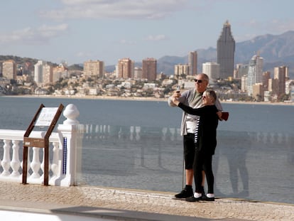 Una pareja de turistas se toma una foto en Benidorm.