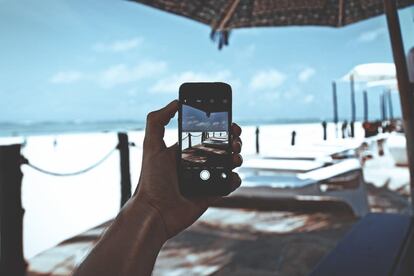 Un usuario utiliza un teléfono móvil en la playa.