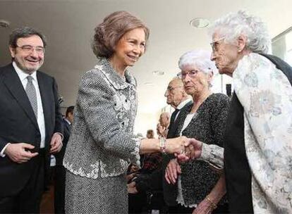 La Reina y el presidente de Caixa Catalunya, Narcís Serra, saludan a pacientes del nuevo centro.