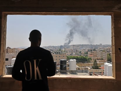 Un palestina observa dos columnas de humo provocadas por ataques israelíes en Yenin.