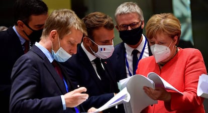 El presidente Pedro Sánchez (izq.), el presidente francés, Emmanuel Macron, y la canciller alemana, Angela Merkel, examinan documentos durante la cumbre de la UE en Bruselas este lunes.