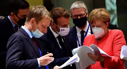 El presidente Pedro Sánchez (izq.), el presidente francés, Emmanuel Macron, y la canciller alemana, Angela Merkel, examinan documentos durante la cumbre de la UE en Bruselas este lunes.