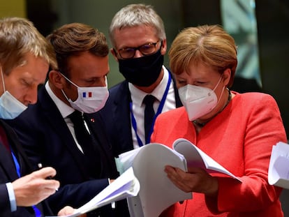El presidente Pedro Sánchez (izq.), el presidente francés, Emmanuel Macron, y la canciller alemana, Angela Merkel, examinan documentos durante la cumbre de la UE en Bruselas este lunes.