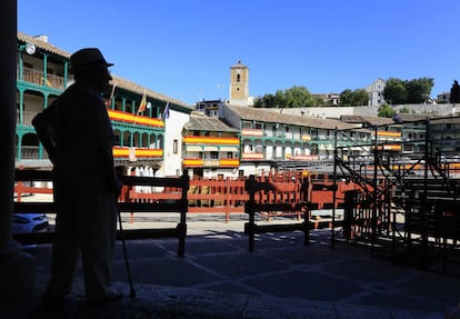 Un vecino en la plaza Mayor de Chinchón, adornada con banderas de España.