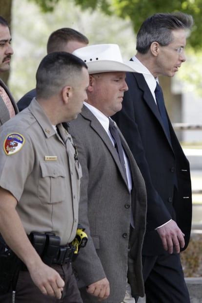 Warren Jeffs (con gafas), líder de la secta mormona, sale escoltado del juzgado de San Ángelo (Tejas) .