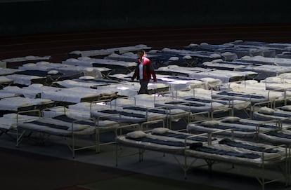 Una mujer camina entre una multitud de camas en un nuevo centro de acogida de emergencia para refugiados en el August Scherttner Hall, en Hanau (Alemania).