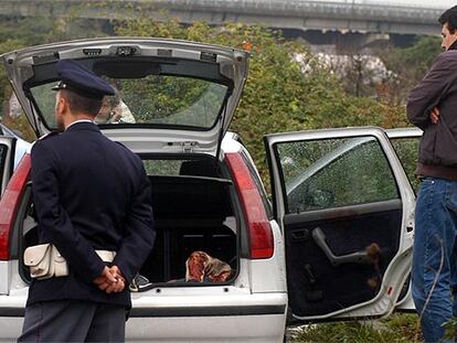 Unos <i>carabinieri</i> inspeccionan el cuerpo de un hombre hallado el martes pasado en un coche cerca de Nápoles.