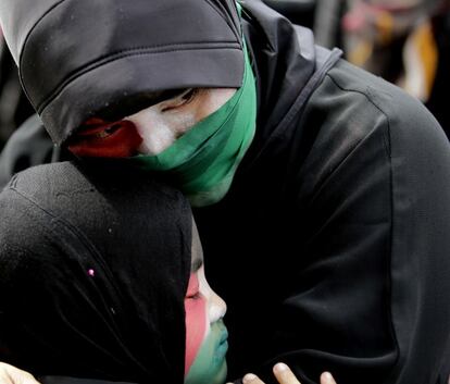 Una madre filipina musulmana abraza a su hija, durante una oración en homenaje a los palestinos asesinados en ataques aéreos israelíes en Gaza, frente a la embajada de Israel, en Taguig (Filipinas). 15 de julio 2014.