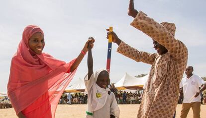 Dos habitantes de Kudaru, un pueblo de Nigeria celebran que la niña Dorcas, de siete años, ha recibido un tratamiento para prevenir la oncocercosis la filariasis linfática,dos enfermedades que corría riesgo de padecer y que están consideradas como dos de las dolencias tropicales desatendidas en el mundo.