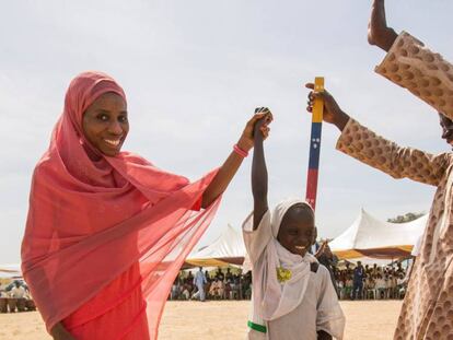 Dos habitantes de Kudaru, un pueblo de Nigeria celebran que la niña Dorcas, de siete años, ha recibido un tratamiento para prevenir la oncocercosis la filariasis linfática,dos enfermedades que corría riesgo de padecer y que están consideradas como dos de las dolencias tropicales desatendidas en el mundo.