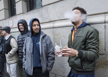 Un hombre fuma en una pipa de agua mientras espera para adquirir cannabis legal en una tienda gubernamental de Montreal (Canadá).