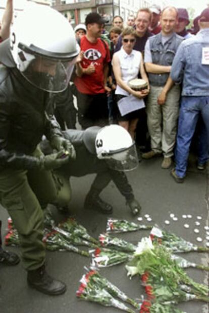 Dos 'carabinieri' depositan velas en el lugar en el que ayer falleció el manifestante.