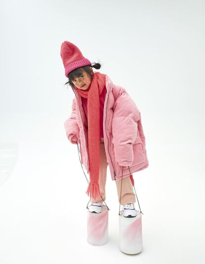 Yu va
con plumas de pana y
gorro de lana, ambos
de Stella McCartney,
sudadera fucsia de
Marni, bufanda larga
de mohair flúor de
Maan, pantalón rosa
acampanado de
Bonpoint y zapatillas
de New Balance. Los
zancos son dos latas
de pintura y un cordel.