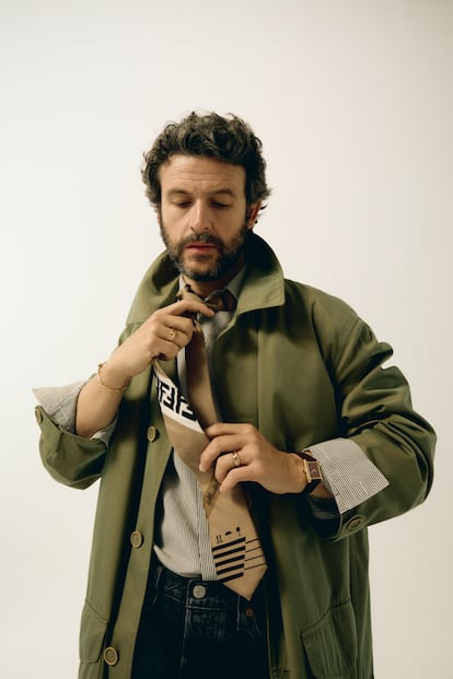 Diego Martín is wearing a Fendi shirt, trench coat and tie with Levi's pants.  The watch and jewelry are Cartier.