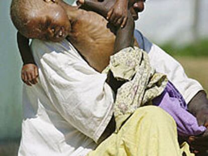 Un enfermero con un niño víctima del hambre, en un hospital de Kuito (Angola).