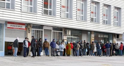 Varias personas hacen cola ante una oficina del INEM.