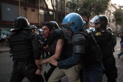 Unos policías reducen a un manifestante.