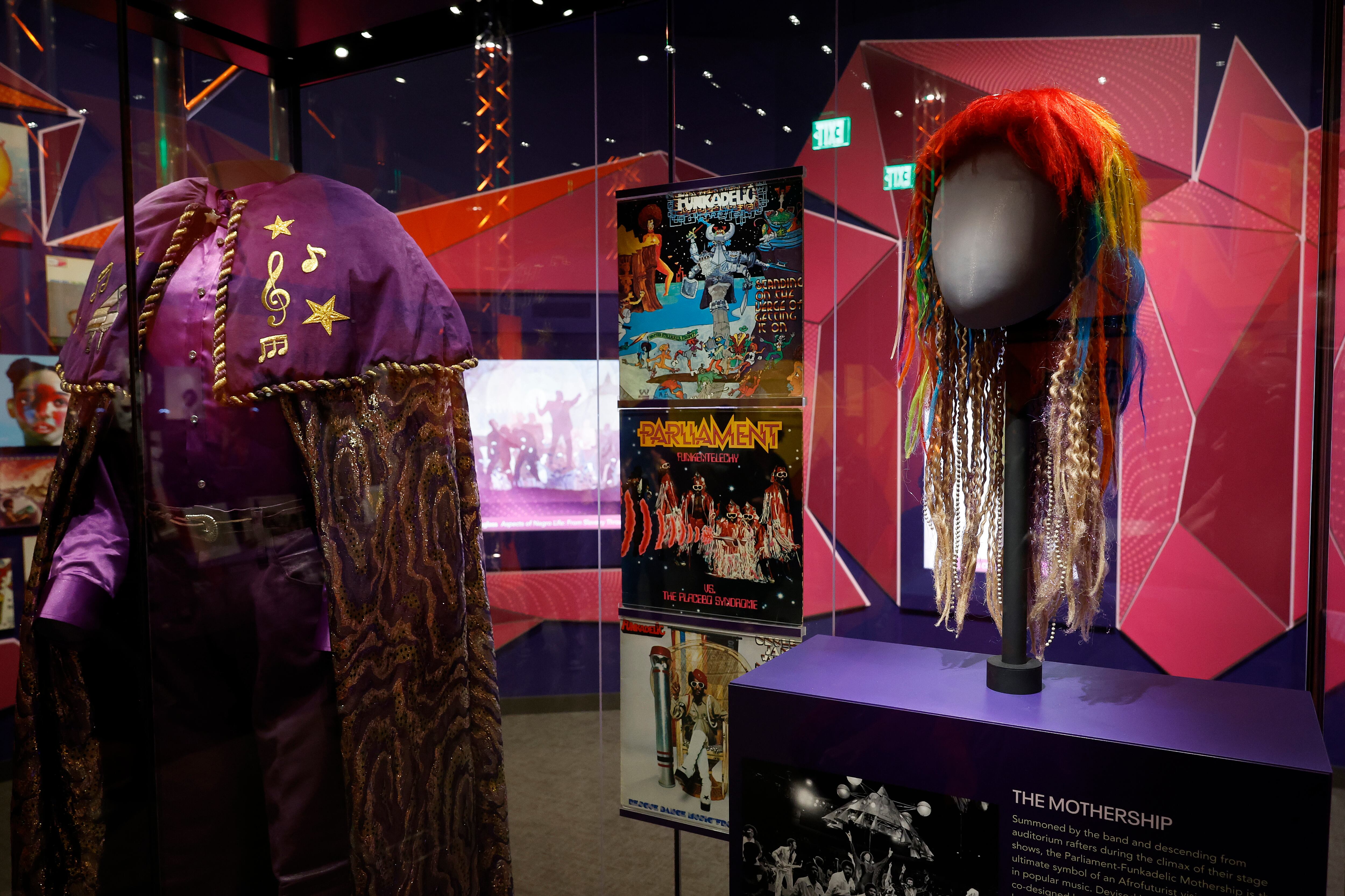 Vitrina dedicada en la exposición al colectivo de funk de ciencia ficción Parliament-Funkadelic, con el traje (izquierda) que usaba el teclista Bernie Worrell en el escenario y una de las pelucas de George Clinton. 