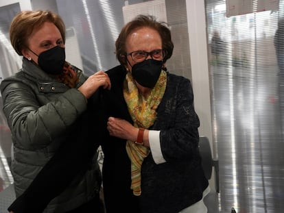 María Herrero, de 97 años, se pone el abrigo tras vacunarse en el centro de salud Barrio del Pilar junto a su hija Duli Sánchez, de 67.