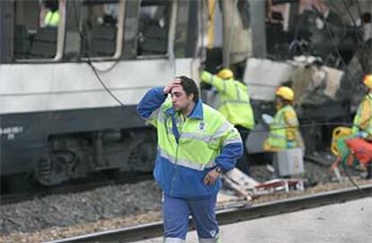 Un empleado del Ayuntamiento de Madrid se lleva la mano a la cabeza ante el vagón que sufrió el atentado en la estación de Santa Eugenia.