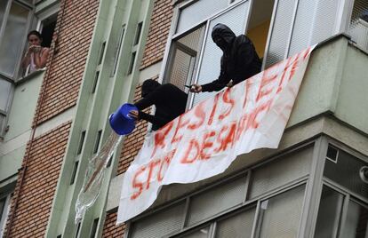 Activistas de Stop Desahucios lanzan cubos de agua desde la vivienda para evitar que la policía entre.