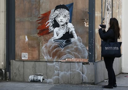 Una mujer observa el grafiti de Banksy que apareci&oacute; en enero frente a la embajada francesa en Londres. 